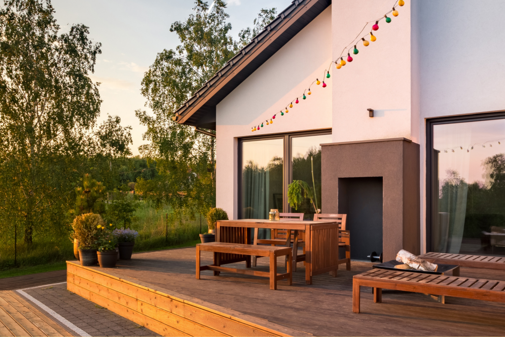 Muted & warm colours - white house with wooden decking, dining set and sun loungers